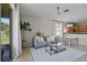Bright living room with ceiling fan, modern sofa and views of the kitchen and patio at 2024 Beardsley Dr, Apopka, FL 32703