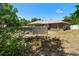 Green backyard with an above-ground pool, wooden deck, fence, and landscaping at 2074 S Parkton Dr, Deltona, FL 32725