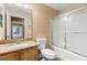 Well-lit bathroom featuring a granite vanity top, sink, toilet and shower with glass doors at 2074 S Parkton Dr, Deltona, FL 32725