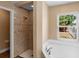 Bright bathroom features a tub and shower with decorative tiles and a window offering natural light at 2074 S Parkton Dr, Deltona, FL 32725