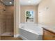 Well-lit bathroom features a soaking tub, tiled shower and a granite vanity at 2074 S Parkton Dr, Deltona, FL 32725