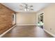 Cozy bedroom with wood-look flooring, ceiling fan, wood accent wall, and sliding glass doors at 2074 S Parkton Dr, Deltona, FL 32725