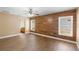 Spacious bedroom featuring wood-look flooring, ceiling fan, accent wall and large windows at 2074 S Parkton Dr, Deltona, FL 32725