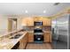 Modern kitchen with granite countertops, stainless steel appliances, and wood cabinets for a functional design at 2074 S Parkton Dr, Deltona, FL 32725
