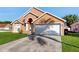 Charming single-Gathering home with a two-car garage, lush lawn, and inviting curb appeal under a clear blue sky at 2108 Shannon Lakes Blvd, Kissimmee, FL 34743