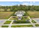 Aerial view of a community garden space with lush green lawns, trees, walkways, and sitting areas at 2524 Datura Loop, St Cloud, FL 34772