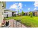 A cozy patio with outdoor seating overlooks the expansive, well-maintained backyard and neighboring homes at 2524 Datura Loop, St Cloud, FL 34772