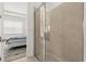 Modern bathroom featuring a glass enclosed tiled shower and an adjacent bedroom with large window at 2524 Datura Loop, St Cloud, FL 34772