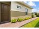 A traditional entry with a brown front door, paver walkway, meticulously manicured landscaping and bright windows at 2524 Datura Loop, St Cloud, FL 34772