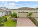 An inviting single-story home with neutral paint, a pristine lawn, and a paver driveway to the two-car garage at 2524 Datura Loop, St Cloud, FL 34772