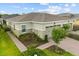 An inviting single-story home with neutral paint, a pristine lawn, and a paver walkway to the front door and two-car garage at 2524 Datura Loop, St Cloud, FL 34772