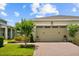 Beige two-car garage door with brick paver driveway and manicured landscaping enhance the curb appeal of this lovely home at 2524 Datura Loop, St Cloud, FL 34772