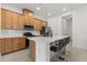 This kitchen features a large island, stainless appliances, stone countertops, and wooden cabinets at 2524 Datura Loop, St Cloud, FL 34772