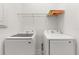 Functional laundry room with modern washer and dryer units and overhead shelving at 2524 Datura Loop, St Cloud, FL 34772