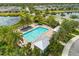 Aerial view of a sparkling blue community pool area with palm trees, lounge chairs, and cabanas for relaxation at 2524 Datura Loop, St Cloud, FL 34772