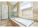 Bathroom featuring large bathtub and glass shower with natural light at 2598 Ekana Dr, Oviedo, FL 32765