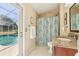 Cozy bathroom with decorative tile shower, granite counters and a direct exit to the outdoor pool at 2598 Ekana Dr, Oviedo, FL 32765