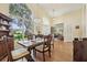 Formal dining room with dark wood table, hardwood floors, bright window, and view to the entry at 2598 Ekana Dr, Oviedo, FL 32765