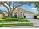 Charming single-story home with a well-manicured lawn, mature trees, and an attached two-car garage at 2598 Ekana Dr, Oviedo, FL 32765