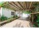 Inviting covered patio with climbing vines, cozy seating, and a charming, shaded outdoor space at 2825 Mayer St, Orlando, FL 32806