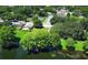 A beautiful aerial shot showcases a neighborhood, tennis courts, and a tranquil pond at 2828 Whispering Way, Winter Park, FL 32792