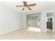 Light-filled bedroom with sliding glass doors, tile floors, ceiling fan and adjacent bathroom at 2828 Whispering Way, Winter Park, FL 32792