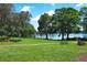 A serene view of a community park featuring lush green spaces, picnic tables and lakeside access at 2828 Whispering Way, Winter Park, FL 32792