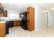 Spacious kitchen with light tile floors, wooden cabinets and modern black refrigerator at 2828 Whispering Way, Winter Park, FL 32792