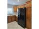 Traditional kitchen featuring brown wood cabinets and black appliances at 2828 Whispering Way, Winter Park, FL 32792