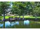 A scenic view of a pond featuring mature trees and a peaceful boardwalk at 2828 Whispering Way, Winter Park, FL 32792