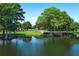 A scenic view of a pond featuring mature trees and a peaceful boardwalk at 2828 Whispering Way, Winter Park, FL 32792