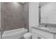 Well-lit bathroom features granite countertops, a white vanity, gray tiled walls, and a bath and shower at 2908 Lingo Ln, Orlando, FL 32822