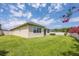 Well-manicured backyard showcasing the home's exterior, healthy lawn, and flowering bushes at 2938 Bushmead Ct, Ocoee, FL 34761