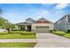 Charming single-Gathering home featuring a manicured lawn, brick driveway, and a two-car garage at 2938 Bushmead Ct, Ocoee, FL 34761