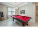 Elegant game room with pool table, chandelier, and natural light at 2938 Bushmead Ct, Ocoee, FL 34761