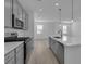 Bright, open kitchen with gray cabinets, stainless appliances, and an island with counter seating at 305 Platform Ln, Debary, FL 32713