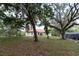 Expansive backyard featuring mature trees, lush green grass, and outdoor seating area at 3437 Coronet Ave, Orlando, FL 32833