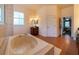 A stunning bathroom with a jacuzzi tub, wood vanity, and an open doorway to the primary bedroom at 3437 Coronet Ave, Orlando, FL 32833