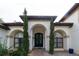 Stately home entrance with arched windows, a decorative door, and manicured landscaping for curb appeal at 3437 Coronet Ave, Orlando, FL 32833