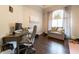 A well-lit home office features a large window, hardwood floors, and a comfortable seating area at 3437 Coronet Ave, Orlando, FL 32833