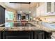 The open kitchen features granite countertops, stainless steel appliances, and views into the Gathering room at 3437 Coronet Ave, Orlando, FL 32833