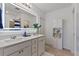 Bright bathroom with double vanity, modern lighting, and large mirror at 423 Pine Tree Blvd, Lake Alfred, FL 33850