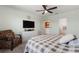 Comfortable bedroom with a plaid comforter, tv, and reading chair at 423 Pine Tree Blvd, Lake Alfred, FL 33850