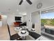 Modern dining area adjacent to the living room, featuring a glass table and access to a patio with scenic views at 423 Pine Tree Blvd, Lake Alfred, FL 33850