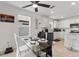 A stylish dining area with a glass table, ceiling fan, and natural light, perfect for Gathering meals and gatherings at 423 Pine Tree Blvd, Lake Alfred, FL 33850