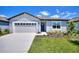 Inviting single-story home with a well-manicured lawn, featuring a two-car garage and a cozy front entrance at 423 Pine Tree Blvd, Lake Alfred, FL 33850