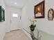 Bright foyer with neutral tile floors, glass-topped console table and white front door at 423 Pine Tree Blvd, Lake Alfred, FL 33850