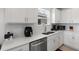 Well-lit kitchen featuring sleek white cabinetry, stainless steel appliances, and ample counter space for culinary activities at 423 Pine Tree Blvd, Lake Alfred, FL 33850