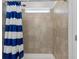 Tiled shower with a blue and white striped shower curtain at 423 Pine Tree Blvd, Lake Alfred, FL 33850