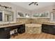 Bright bathroom with a soaking tub with stone surround and dual vanities at 434 S Beach St, Ormond Beach, FL 32174
